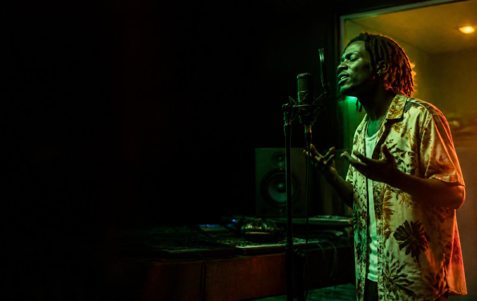 Artist recording in a dark studio booth